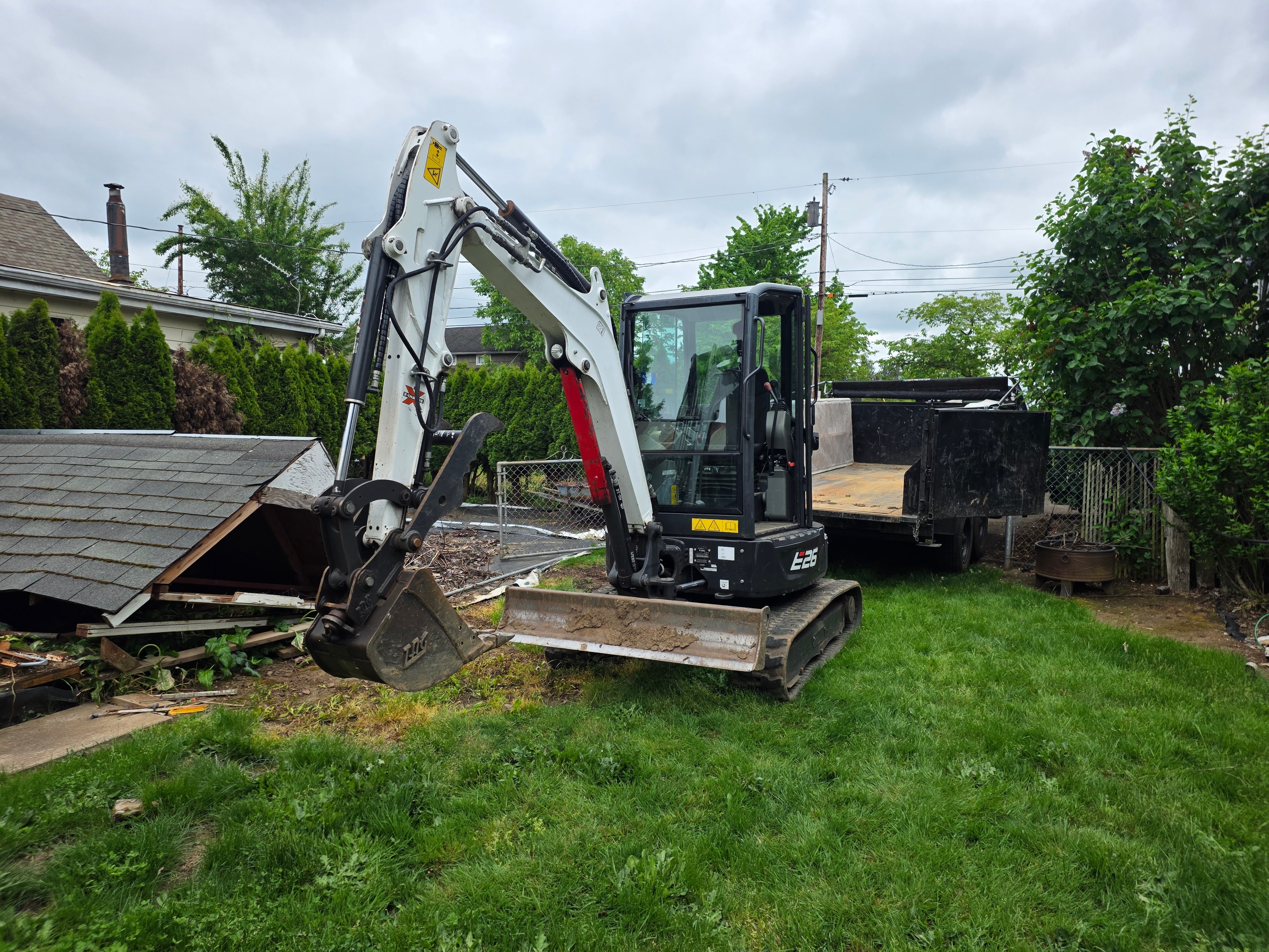 Mini excavator beginning demolition of accessory building