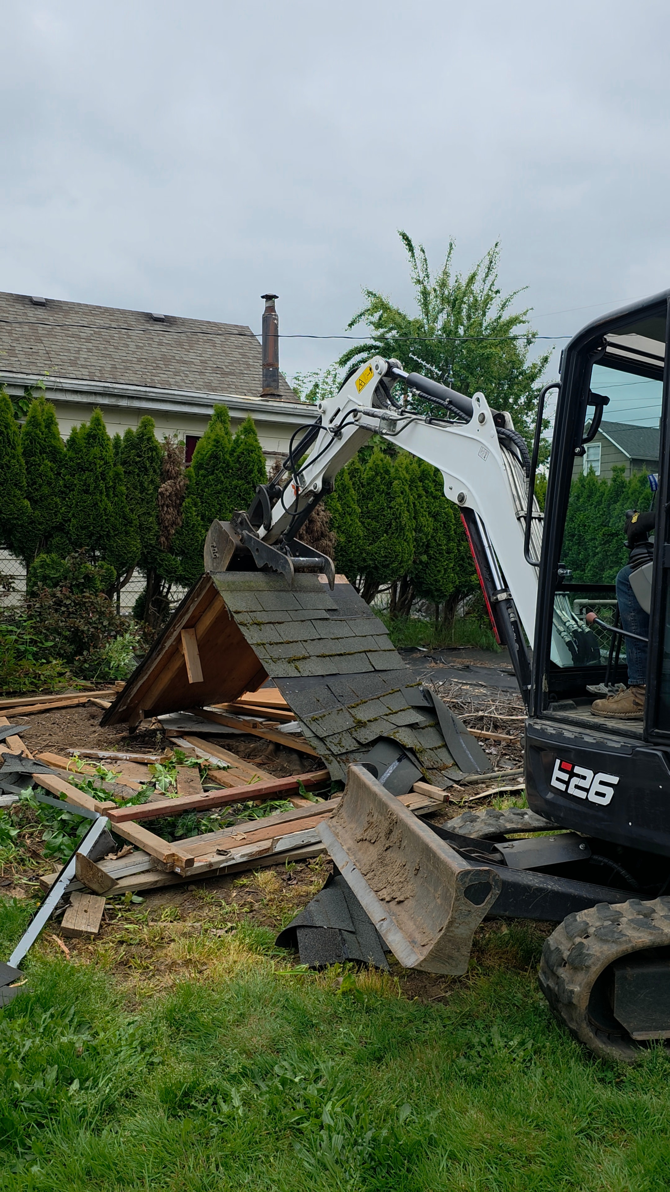 Mini excavator clearing remaining structure and debris