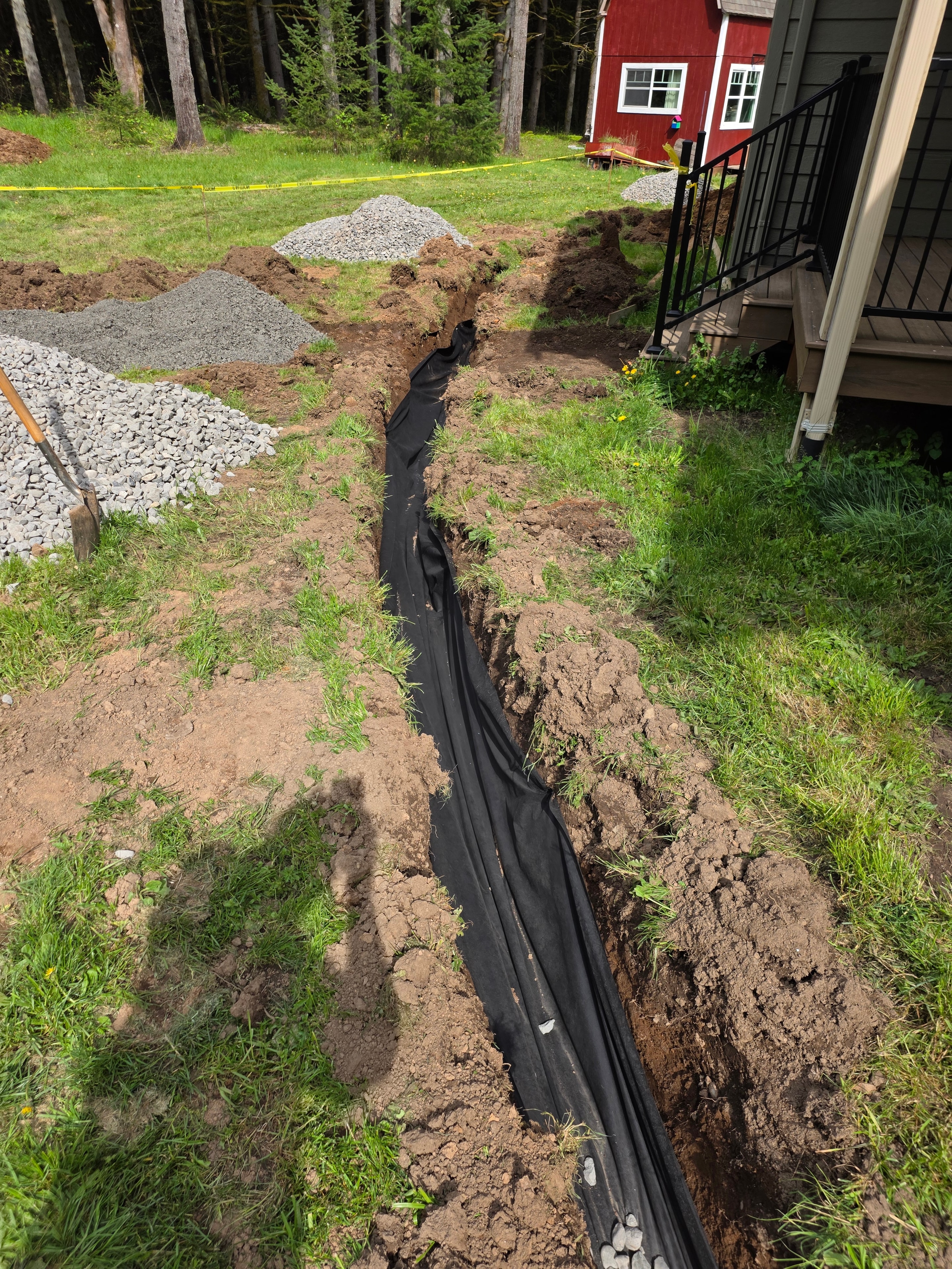 Drain trench showing depth and routing path toward backyard