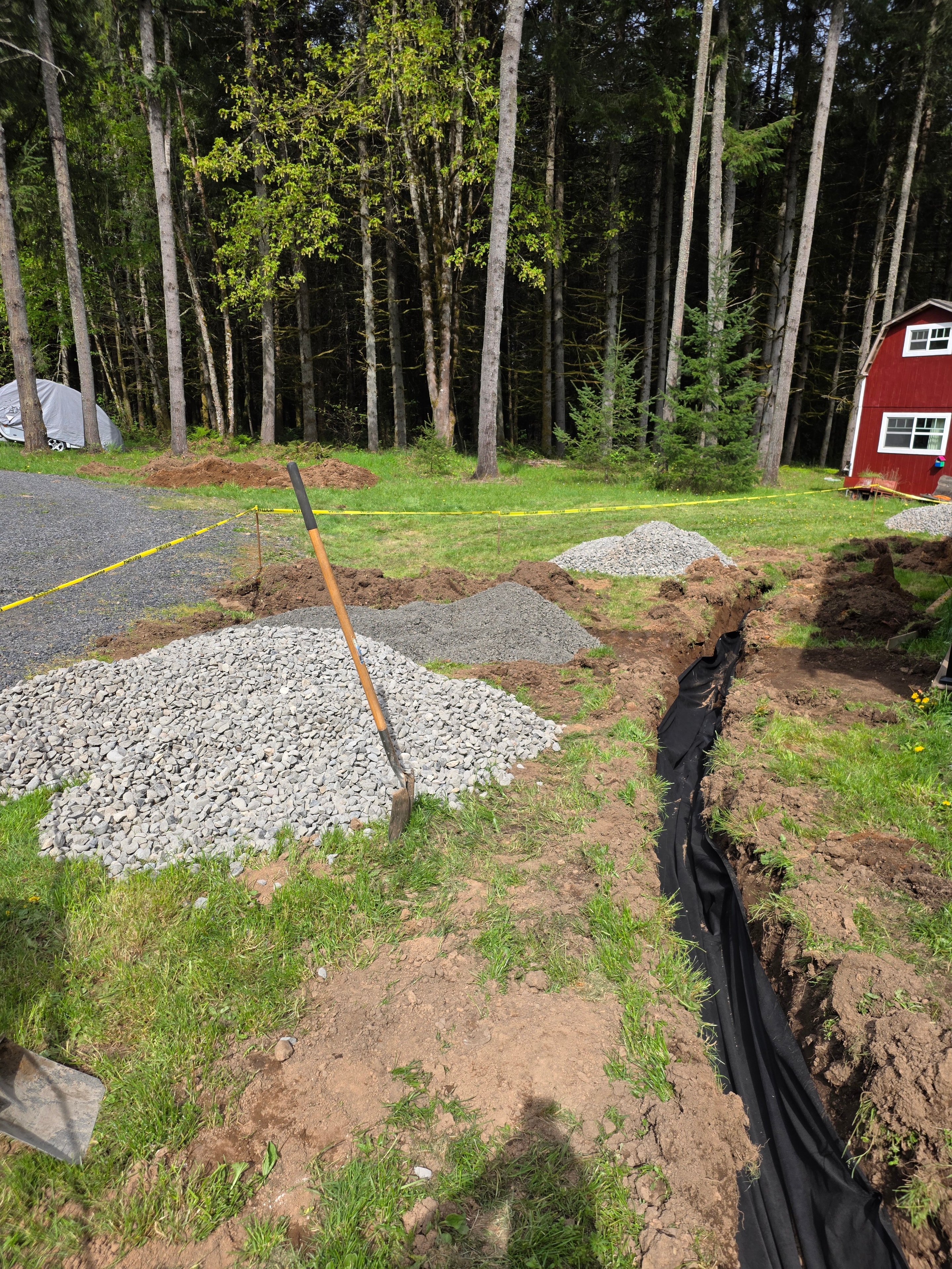 Perforated drain pipe being installed in trench